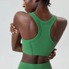 A model wearing a bright green high-impact stretch yoga crop top and matching bottoms.