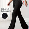 A woman models black Ladies' bell bottom pants with a high waist and flared legs.