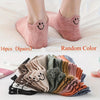 A collection of 16 pairs of low-cut ankle socks with smiling embroidery in various random colors.