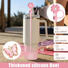 A pink thickened silicone boot with a flower straw and charm hanging from it, shown next to a tumbler.