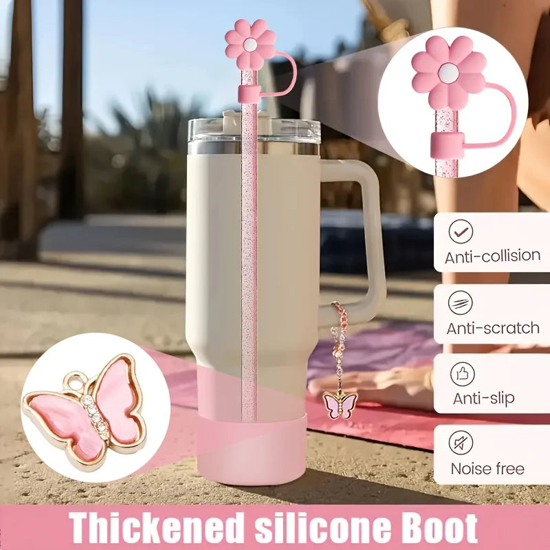 A pink thickened silicone boot with a flower straw and charm hanging from it, shown next to a tumbler.