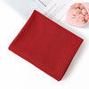 A red microfiber cooling towel with a black geometric pattern is shown on a white surface.