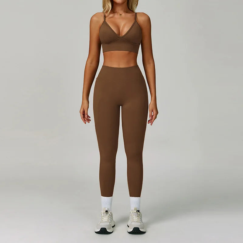 Eine Frau modelliert ein nahtloses Sport-Yoga-Set in Braun, bestehend aus einem Cropped-Top und einer langen Leggings.