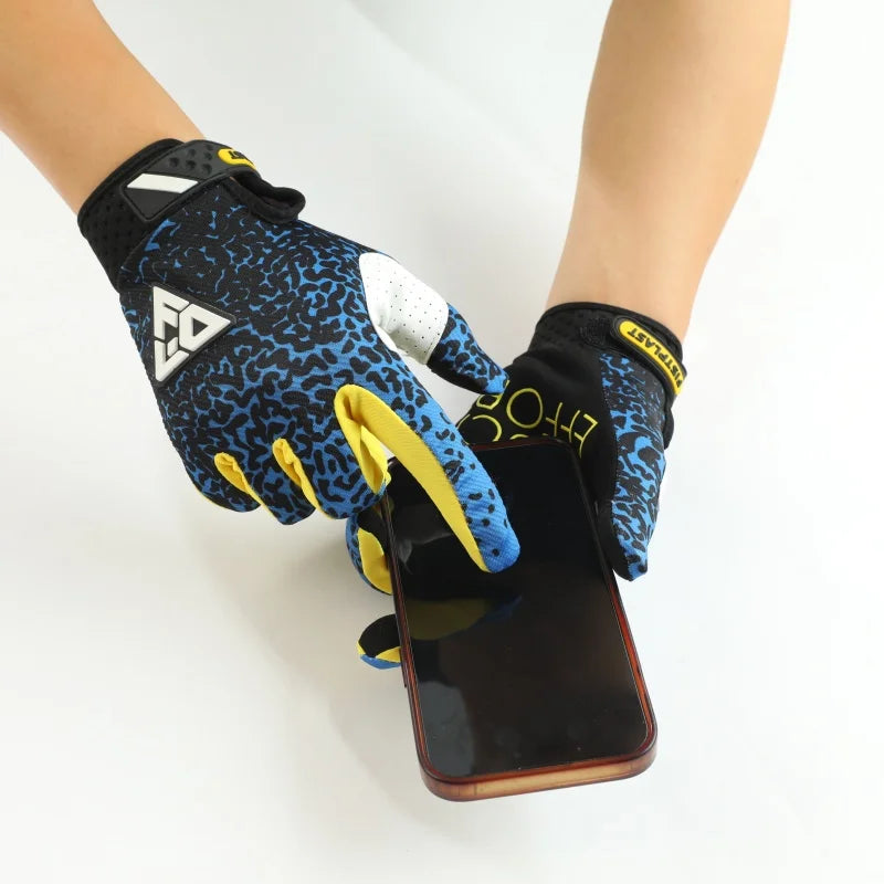 A hand wearing black and yellow full finger motocross gloves holding a smartphone.
