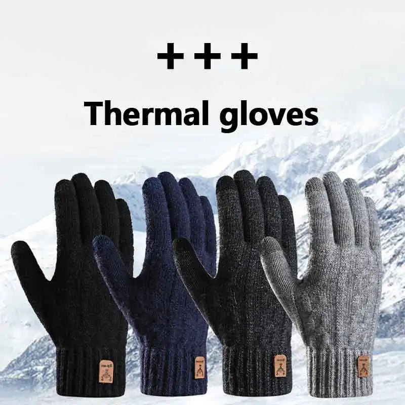 A close-up of black and navy thermal gloves shown against a snowy mountain background.