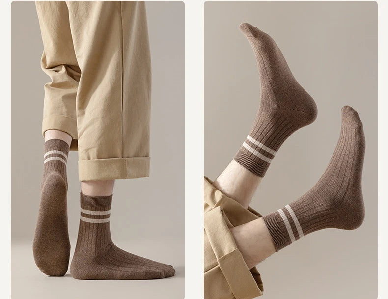 A pair of brown casual striped men's socks worn on a foot, shown in a close-up view.