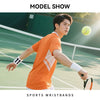 Un jeune homme en chemise orange joue au tennis, portant des bracelets blancs et tenant une raquette.