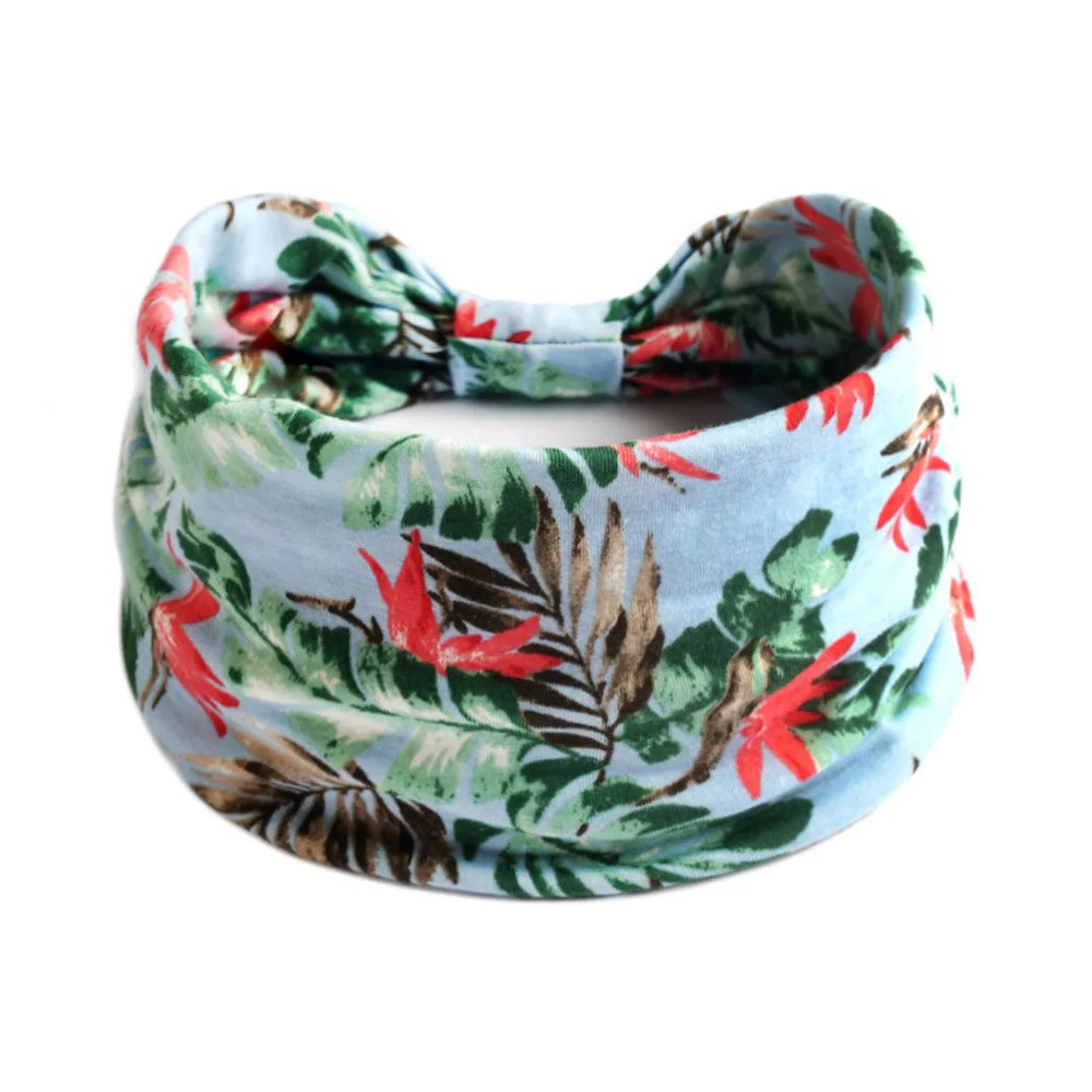 A floral patterned cotton stretch headband featuring red and green leaves.