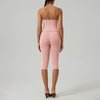 Eine Frau trägt ein pinkes zwei-teiliges Yoga-Activewear-Set mit Crop-Top und Leggings.