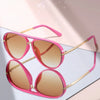 Pink gradient aviator sunglasses with gold accents shown against a light background.