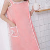 A woman wearing a pink cotton wearable bath towel or robe in a soft fleece material.