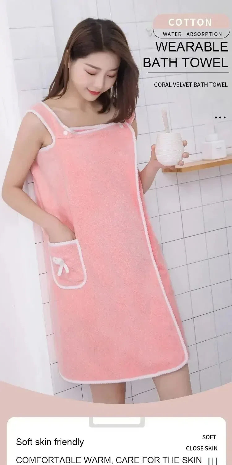 A woman wearing a pink cotton wearable bath towel or robe in a soft fleece material.