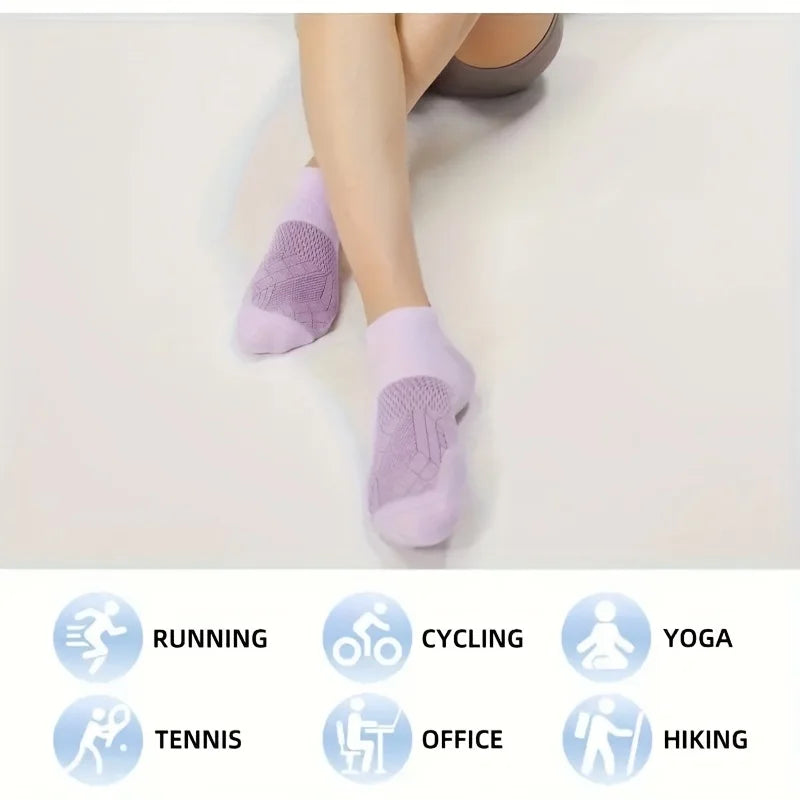 A pair of purple performance compression ankle socks are shown on a person's foot, with icons indicating various activities l