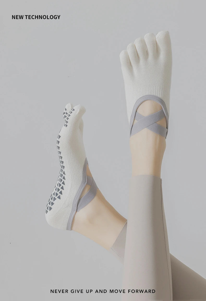 A close-up of a person's foot wearing white five-finger yoga and fitness socks with gray accents.