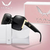 A pair of black and gold trendy square sunglasses resting on a white cloth next to their packaging box.