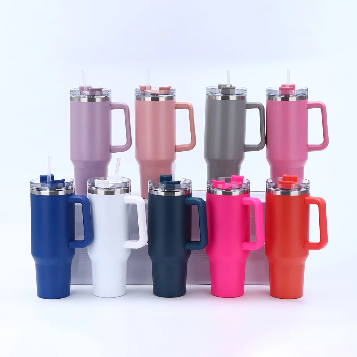 Une rangée de huit grandes tasses isothermes en acier inoxydable de différentes couleurs, y compris rose, violet, gris et ora