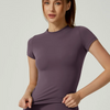Una mujer modela un conjunto deportivo de yoga color malva, de cintura alta, en un estudio.
