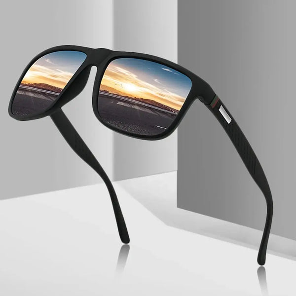 A pair of black designer sunglasses with mirrored lenses reflecting a sunset sky.