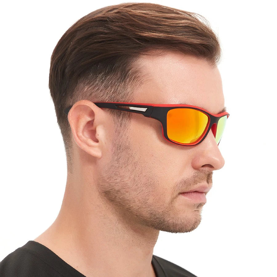 A man wearing orange-tinted sunglasses with black frames against a white background.