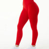 Une personne portant des leggings de yoga rouges sans couture taille haute et des baskets blanches.