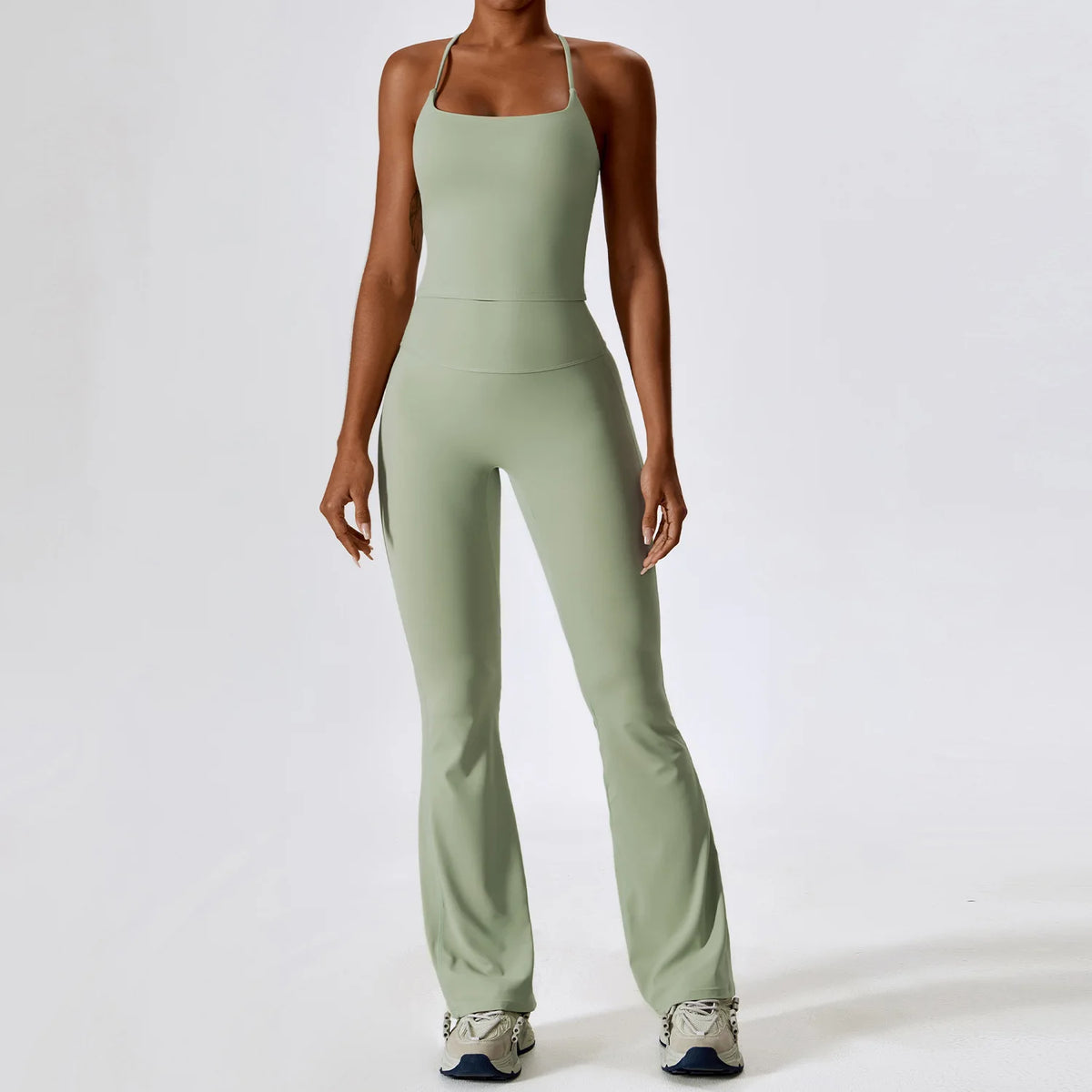 A woman wearing a light sage green women's performance tracksuit set.
