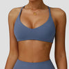 A woman wearing a solid blue high-support sports bra for yoga and fitness.