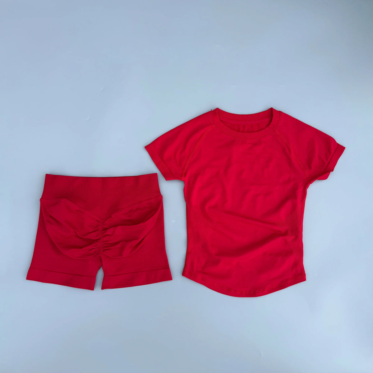 Ensemble de yoga et fitness rouge sans couture pour femmes, comprenant un haut à manches courtes et un short assorti.