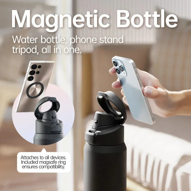 A hand holds a silver smartphone attached to a black water bottle using a magnetic ring for a phone stand.