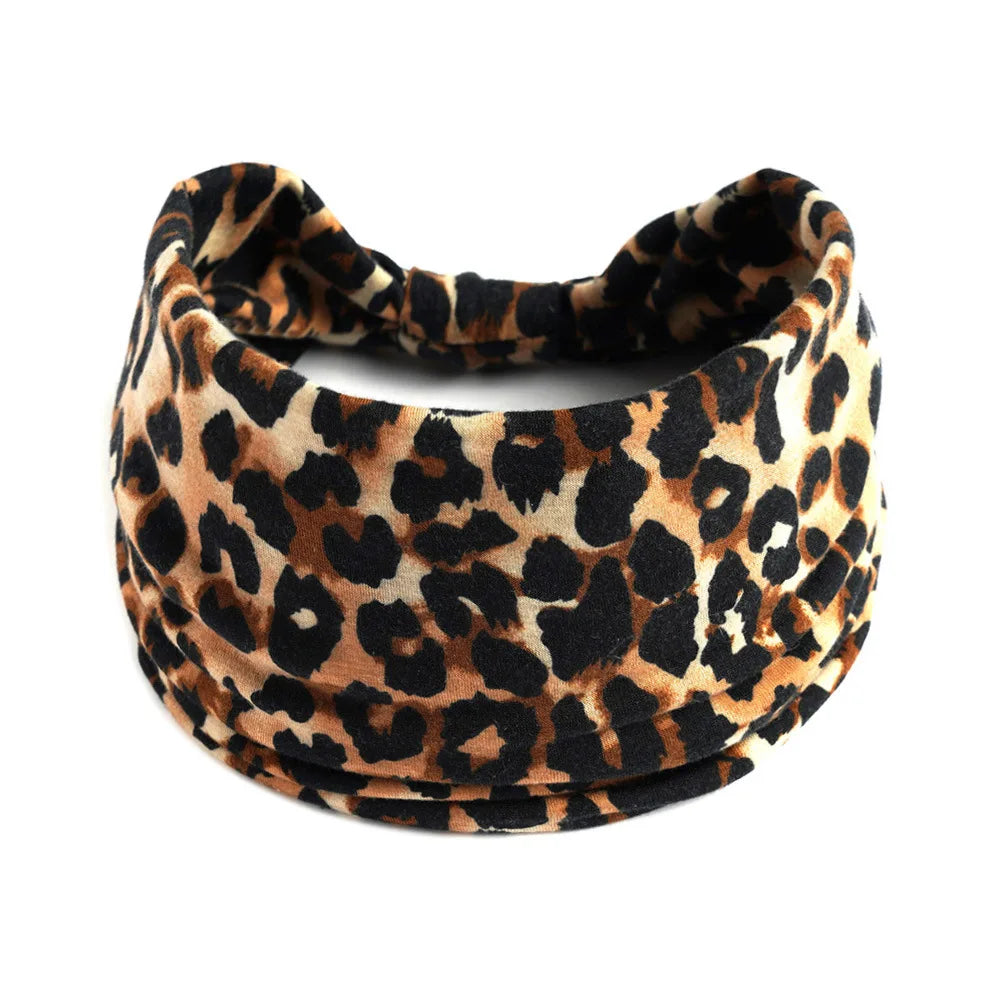 A close-up of a brown and black leopard print cotton stretch headband.