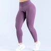 A person is wearing purple high-waisted seamless yoga leggings and white sneakers.