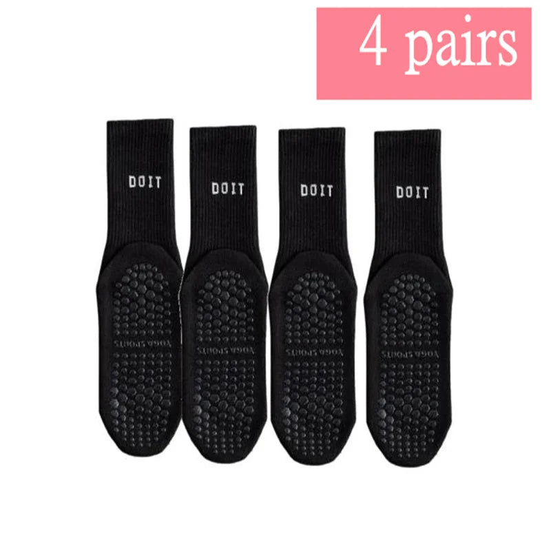 Vier Paar schwarze atmungsaktive, rutschfeste Yoga- und Fitnesssocken in einer Reihe.
