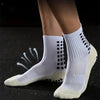 A pair of white non-slip silicone sports socks for football and basketball shown on a dark surface.