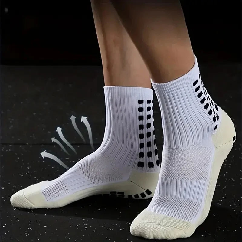 A pair of white non-slip silicone sports socks for football and basketball shown on a dark surface.