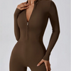 Modelin trägt einen langärmeligen, figurbetonten, dunkelbraunen Zip-Overall.