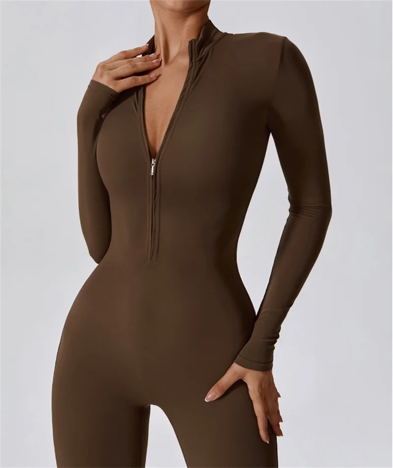 Modelin trägt einen langärmeligen, figurbetonten, dunkelbraunen Zip-Overall.