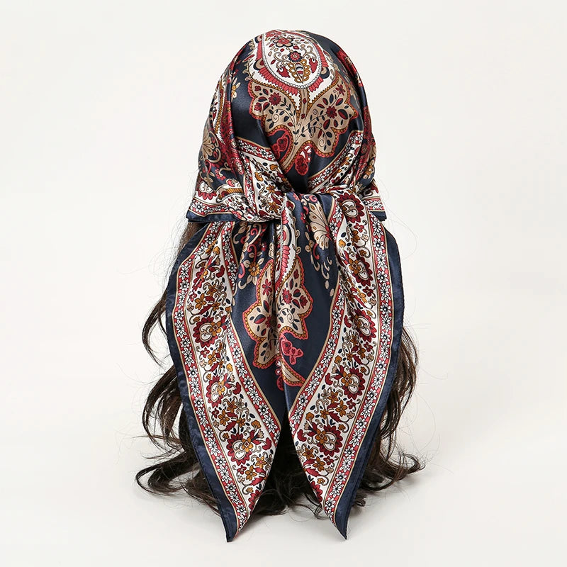 Elegant satin square scarf featuring intricate paisley patterns in deep blue, red, and gold tones