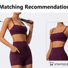 A model wearing a dark purple high-waist yoga or workout set consisting of a sports bra top and matching shorts.