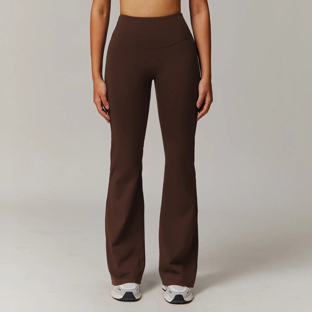 عارضة ترتدي ليقنز (ليقنزات) داكنة البني وواسعة لليوغا واللياقة البدنية.