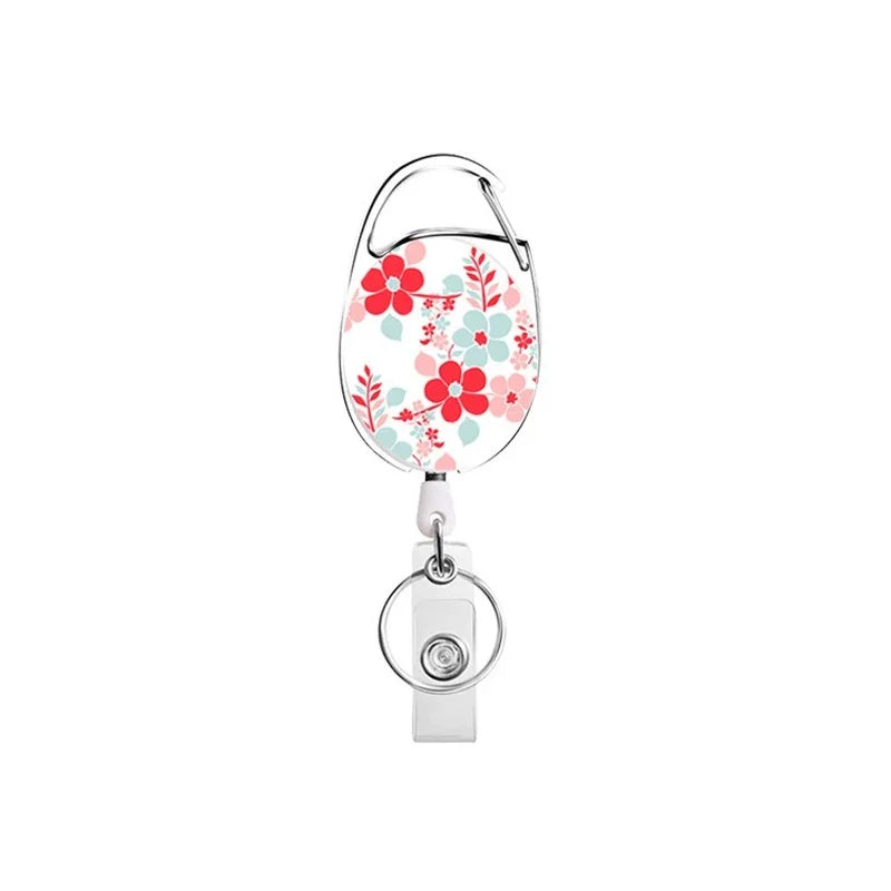 A clear plastic retractable ID badge reel keychain with a floral design.