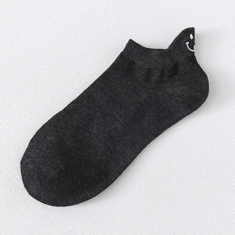 Calcetines negros de tobillo con una carita sonriente bordada en la punta