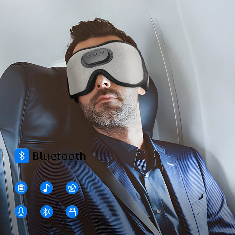 A man wearing sleep headphones with a music feature is seated in a chair.