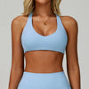 A woman models a light blue padded sport yoga bra and matching bottoms.