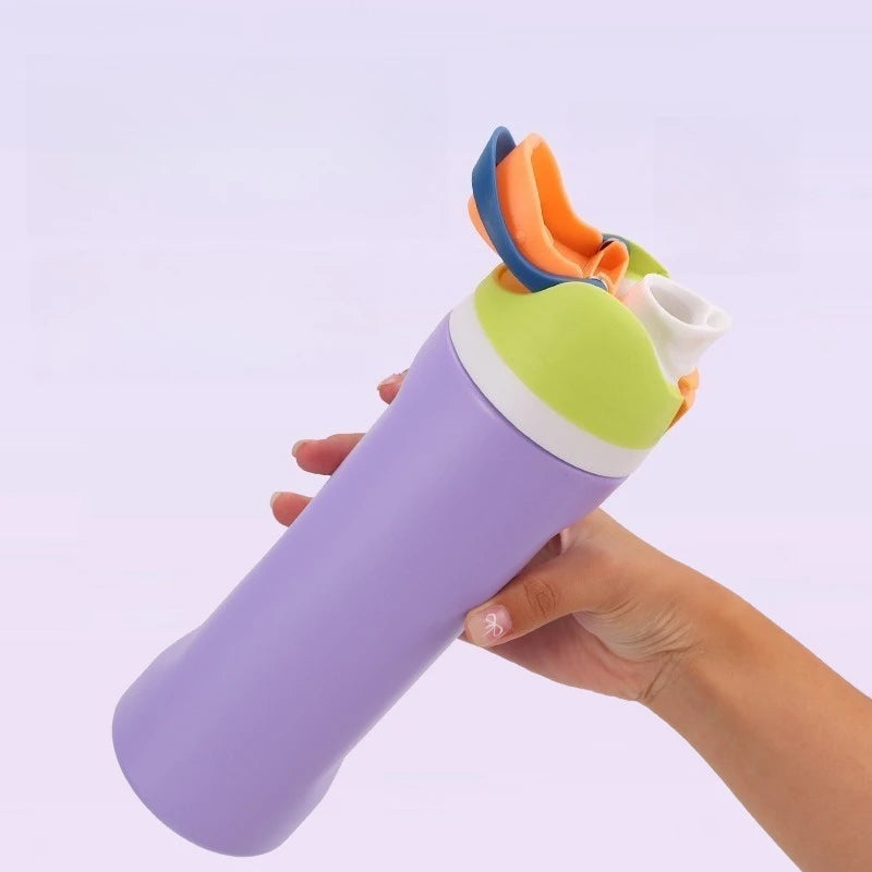 A hand holds a purple stainless steel insulated fitness cup with an orange and blue straw lid.