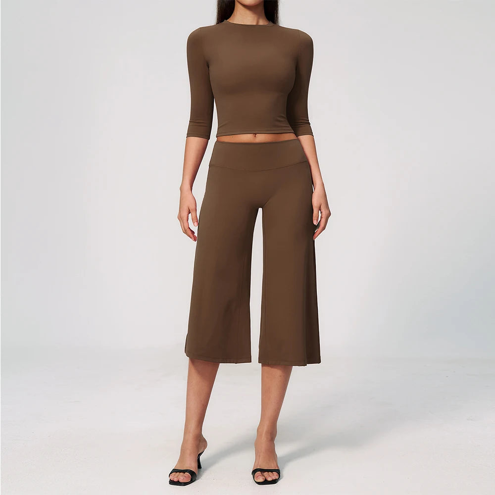 A woman wearing a matching olive brown long-sleeved top and high-waisted leggings for yoga or fitness.