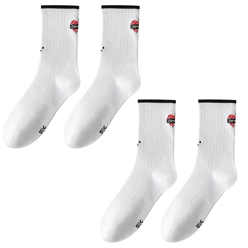 A set of white crew socks with a red logo design shown from the side.