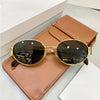 Brown leather sunglasses with gold metal frames resting on a matching leather case.