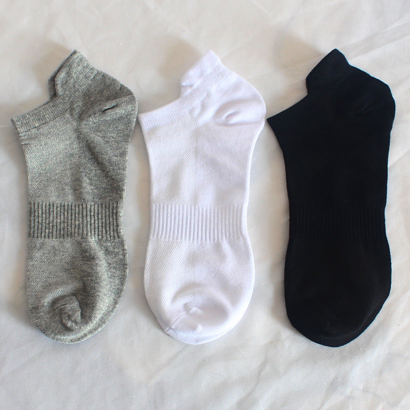 Dreipack aus grauen, weißen und schwarzen Knöchelsocken auf weißem Untergrund.