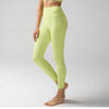 Une personne modélise des leggings de performance taille haute vert lime clair.