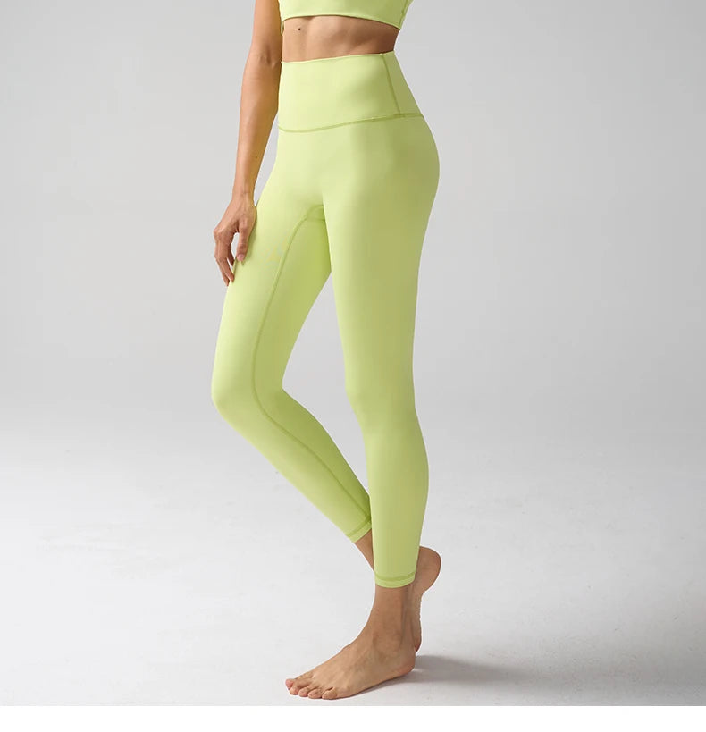 Une personne modélise des leggings de performance taille haute vert lime clair.