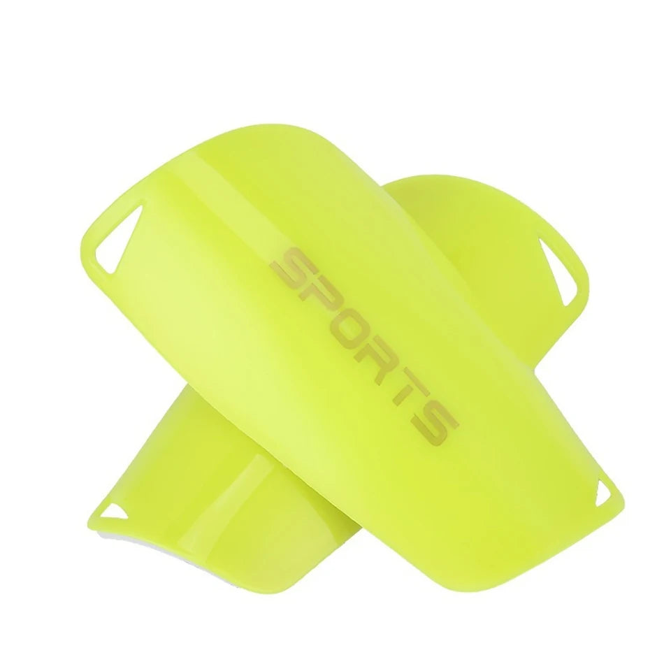 A bright yellow soccer shin guard is shown from the side, featuring the word SPORTS printed on it.